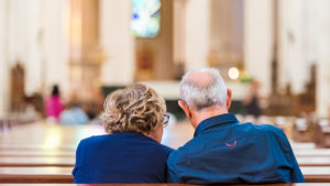 Couple sitting heads together in a Church