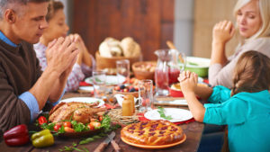 Family Praying at Thanksgiving Meal