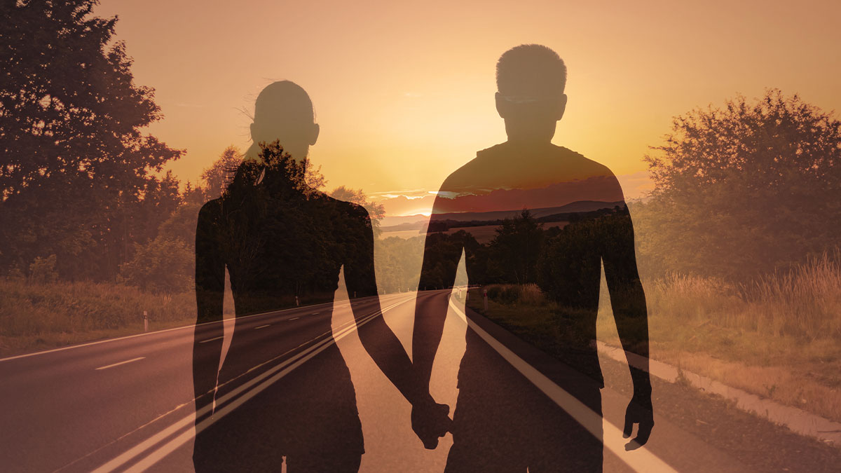 Couple holding hands with road ahead of them