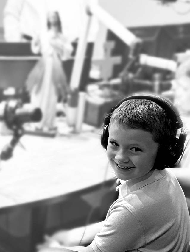 Young boy in the St. Gabriel Radio studio with headphones on. 